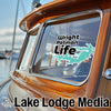 Wright Patman Life sticker on a wooden boat window with Lake Lodge Media logo.