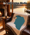 Red Lake, Minnesota map blanket on a leather couch with a fireplace view.