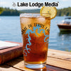 Glass of iced tea with lake outline and compass design, "Lake Lodge Media" logo.