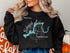 Black sweatshirt with "Beautiful Nickajack Lake Tennessee" and compass graphic.