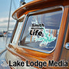 Sticker with "Smith Mountain Life" text and graphic on boat window, "Lake Lodge Media" logo below.