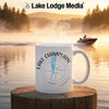 White mug with Lake Champlain compass design, steaming, on wooden post.
