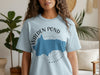 Light blue t-shirt featuring a blue Walden Pond map with compass and Massachusetts text.