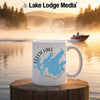 White mug with Leech Lake Minnesota map graphic and steam rising, lakeside scene.