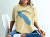 Onondaga Lake, New York map and compass graphic on a light yellow t-shirt.