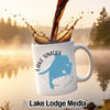White mug with "Lake Simcoe Ontario" map design, coffee pouring into it.