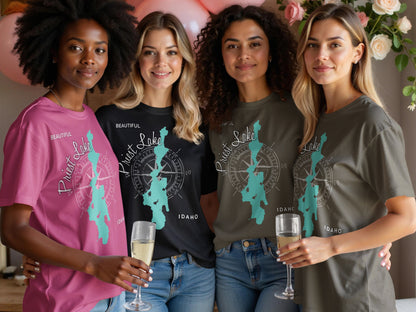 Four women in t-shirts with "Beautiful Priest Lake Idaho" and compass graphic.