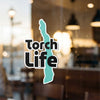 Torch Life sticker on a window with a teal shape and copyright Lake Lodge Media LLC.