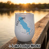 White travel tumbler featuring a blue Gull Lake map and compass design, sitting on a wooden dock at sunset.