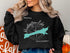 Black sweatshirt featuring Huntington Lake map and compass graphic with text.