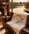 Woven blanket with "Key Largo Florida" and compass on leather couch.