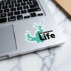 Jocassee Life sticker in teal lake shape on a laptop keyboard.