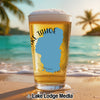Beer glass with "Lake Tahoe" text and outline on a beach with palm trees.