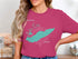 Teal outline of Lake Erie, Ohio, on a pink t-shirt.