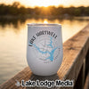 A white stainless steel tumbler rests on a wooden dock with Lake Hartwell graphics printed on the side.