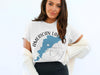 Woman modeling white t-shirt with "American Lake Washington" map and compass design.