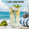 Glass with Seneca Lake design, iced drink, limes, mint, and sunglasses on beach.