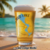 Glass of beer with "Lizard Lake" map and compass on a beach.