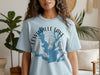 Light blue t-shirt with Lewisville Lake Texas map design and compass rose.