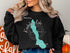 Black sweatshirt with turquoise Lake Chelan map and compass graphic.