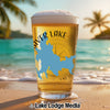 Beer glass with "CALIF" and "AVER LAKE" text on a beach at sunset.