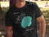 Black t-shirt with a teal lake shape and compass graphic.