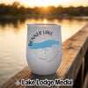 A white travel tumbler printed with a blue map of Donner Lake resting on a wooden dock.