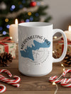 White mug with Merrymeeting Lake, New Hampshire compass design on wooden table with Christmas decor.