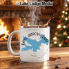 White mug with Lake Arrowhead map and compass design, hot coffee splashing.