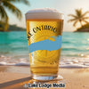Beer glass with "Lake Ontario" text and map on a beach with palm trees and ocean.