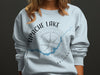Light blue sweatshirt with "Apache Lake Arizona" text and a compass design.