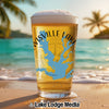Glass of beer with "Lewisville Lake Texas" map design on beach background.