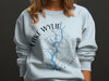 Light blue sweatshirt with "Lake Wylie South Carolina" in a circle around a map and compass.