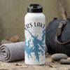 White water bottle with "ERS LAKE GE" and lake map graphic, near rolled towel and duffel bag.