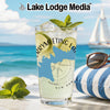 Glass with lime and mint garnish, beach background, and "Lake Lodge Media" text.