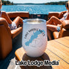 A white insulated wine tumbler with a Lake Marble Falls graphic sits on a boat table.
