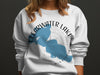 White sweatshirt with a blue shape of Clearwater Lake, Minnesota, and compass graphic.