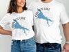 White t-shirts feature a blue Canyon Lake map design with a compass and "Arizona" text.