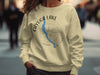 Light yellow sweatshirt with Cayuga Lake map and compass design, "New York" text.