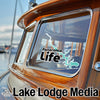 Window sticker with "Panorama Life" text and lake outline, on a boat.
