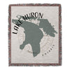 Woven blanket with map of Lake Huron and Ontario, fringed edges.