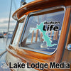 Text "Hudson Life" and "Lake Lodge Media" on a boat windshield and hull.
