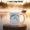 White mug with Evergreen Lake map and compass design, with lake background.