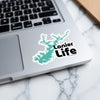 Turquoise lake shape sticker with "Lanier Life" text on laptop keyboard.