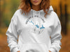 White hoodie with Woods Canyon Lake Arizona compass design and blue fish.