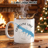 White mug with Grapevine Lake map and compass on wooden table, by fireplace.