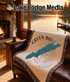 Green Bay Wisconsin blanket with compass design on a leather couch.