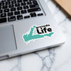 Grenada Life sticker on a laptop with a teal outline of Grenada.