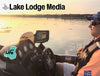 Man in boat at sunset with fish finder and "Emerald Life" sticker; "Lake Lodge Media" text.
