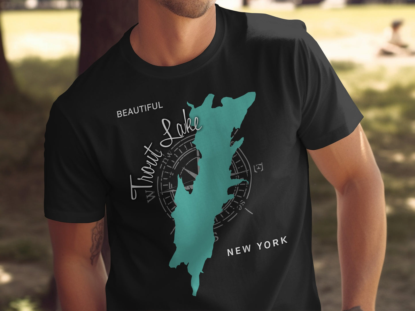Black t-shirt with a teal map outline of Trout Lake, New York.